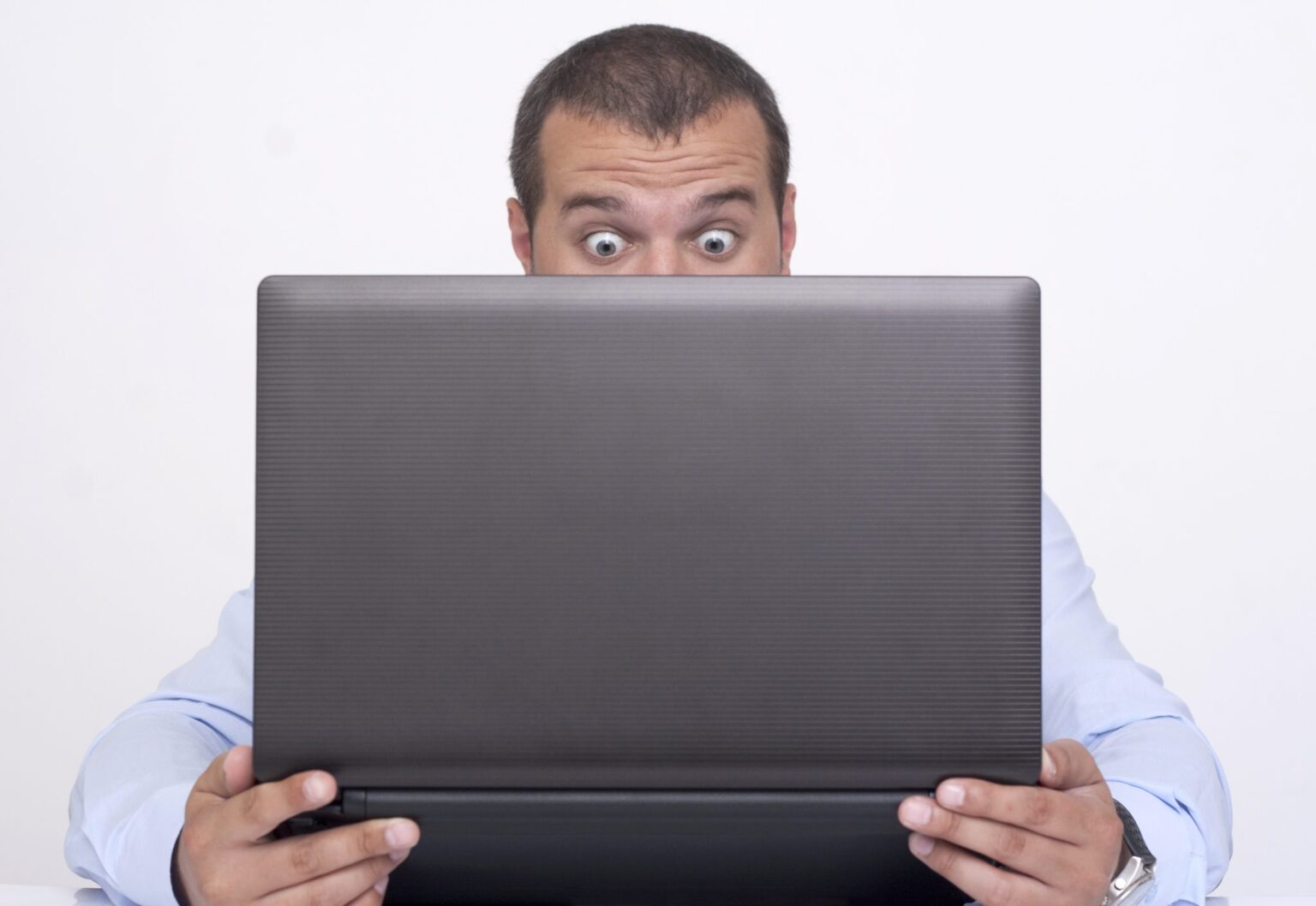 A man expressing surprise with a laptop computer
