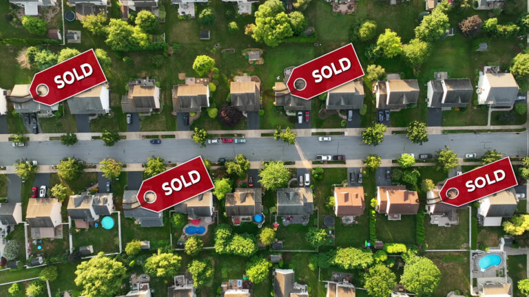 Aerial of a neighborhood with sold signs over several houses. Top