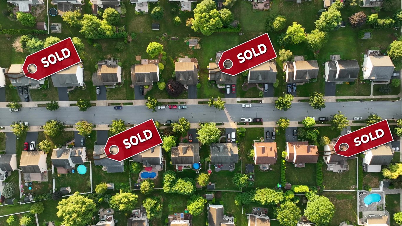 Aerial of a neighborhood with sold signs over several houses. Top